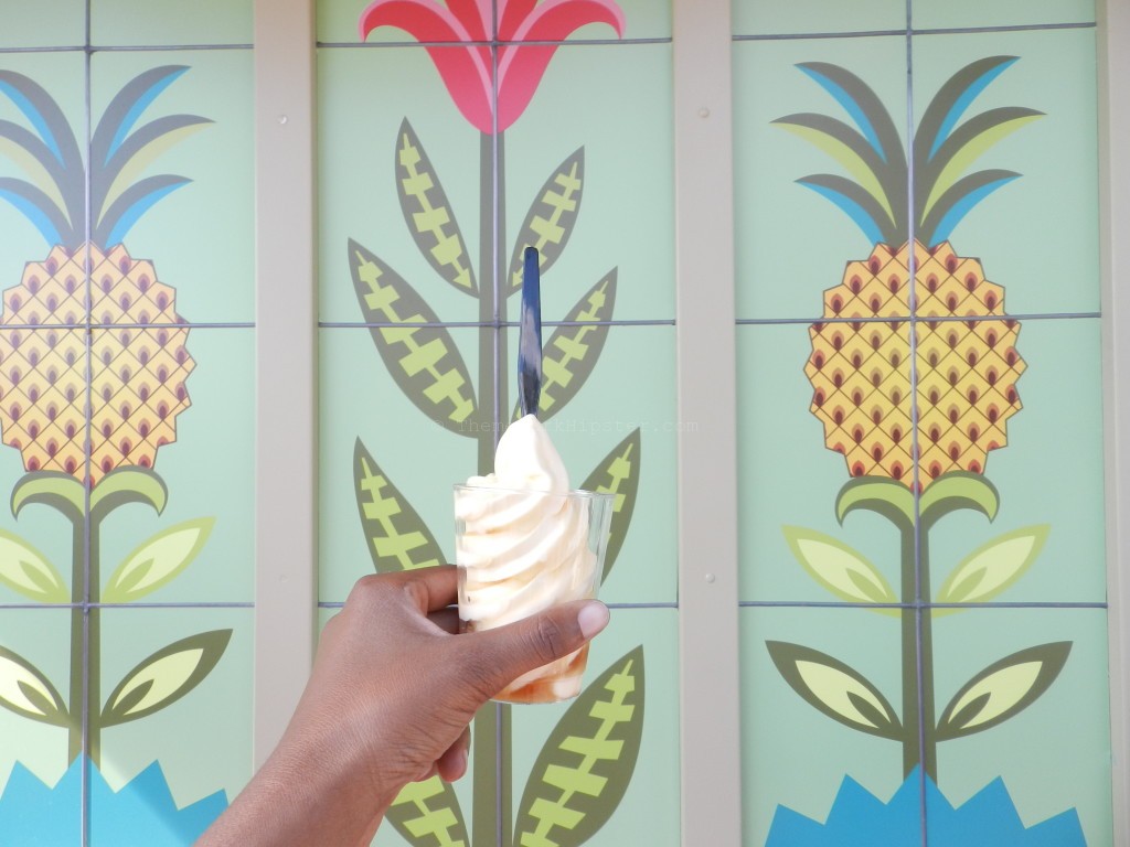Dole Whip in many variations in front of pineapple painted wall at Disney World. Keep reading to get everything you must do at Magic Kingdom and the best things to do at Disney World. Photo copyright Theme Park Hipster.