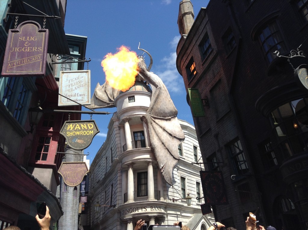 "Diagon Alley: Fantastic Beasts and stuffed animals on shelves and fire-breathing dragon on Gringotts at The Wizarding World of Harry Potter in Universal Studios.