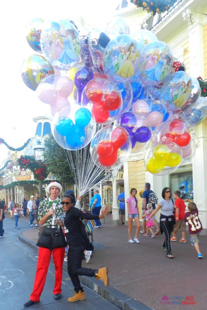 Christmas at Disney Parks with Disney Cast Member Holding Balloons. Keep reading to get an understanding on Walt Disney’s Quote on Courage.