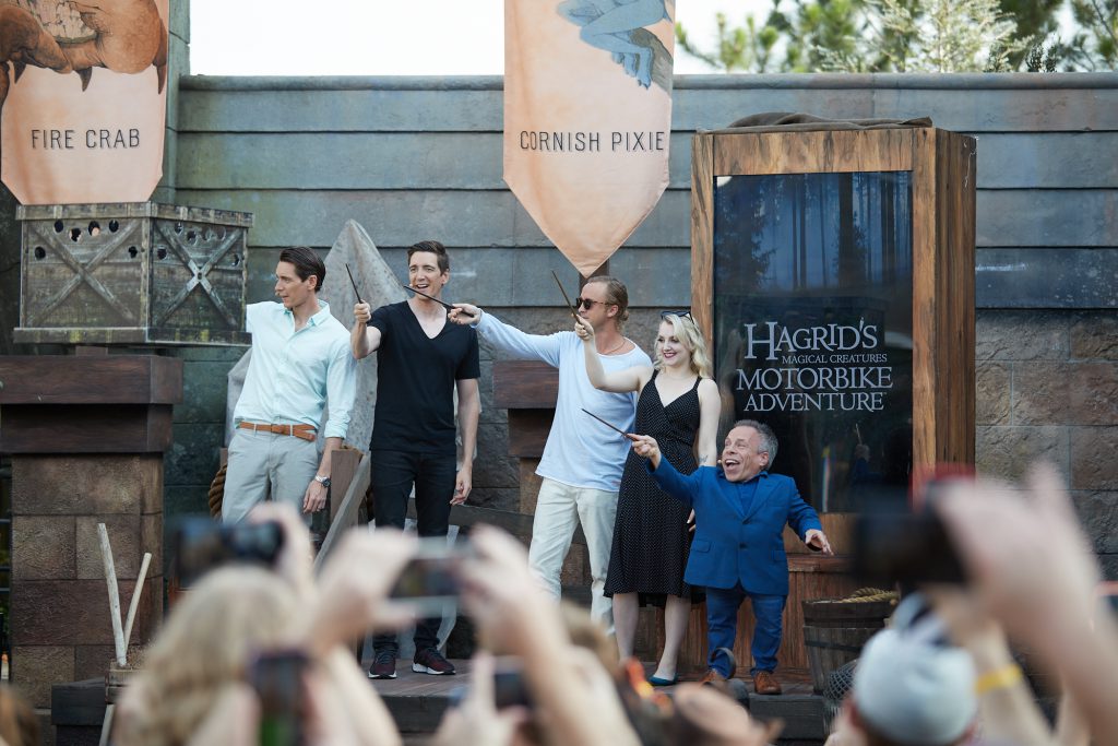 Hagrid Grand Opening Moment with Tom Felton (Draco Malfoy), Evanna Lynch (Luna Lovegood), Warwick Davis (Professor Flitwick), James & Oliver Phelps (Fred & George Weasley) in the Wizarding World of Harry Potter Hogsmeade at Universal Islands of Adventure.
