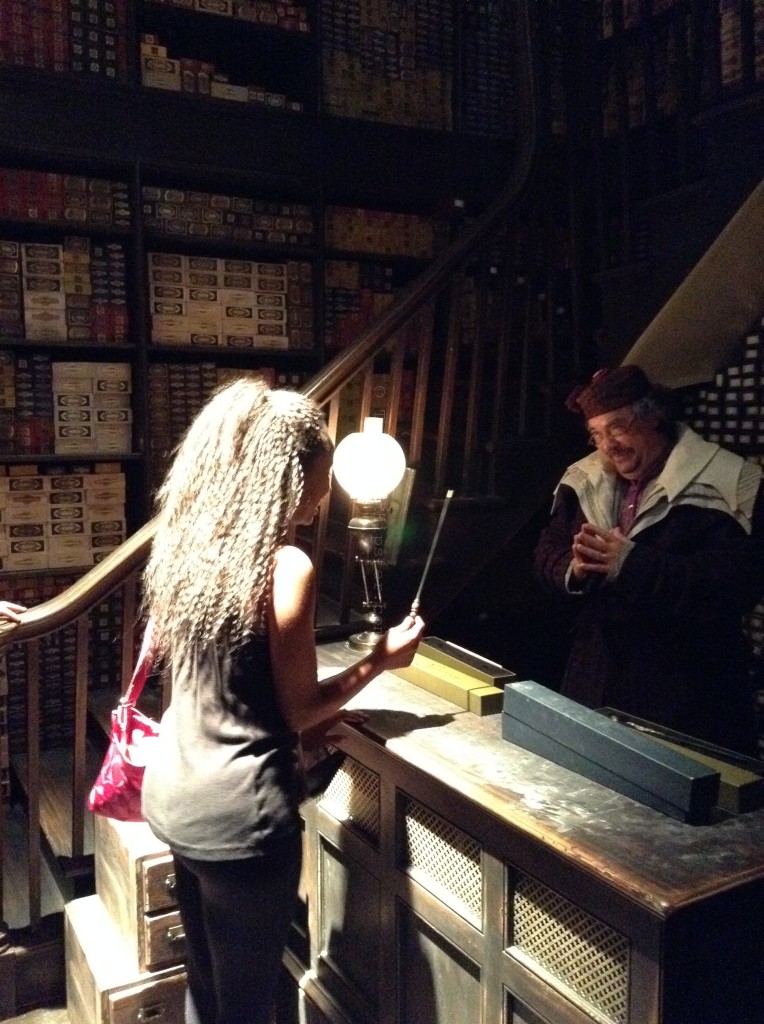 Nikkyj holding wand in Ollivander's Wand Shop in the Wizarding World of Harry Potter Hogsmeade.