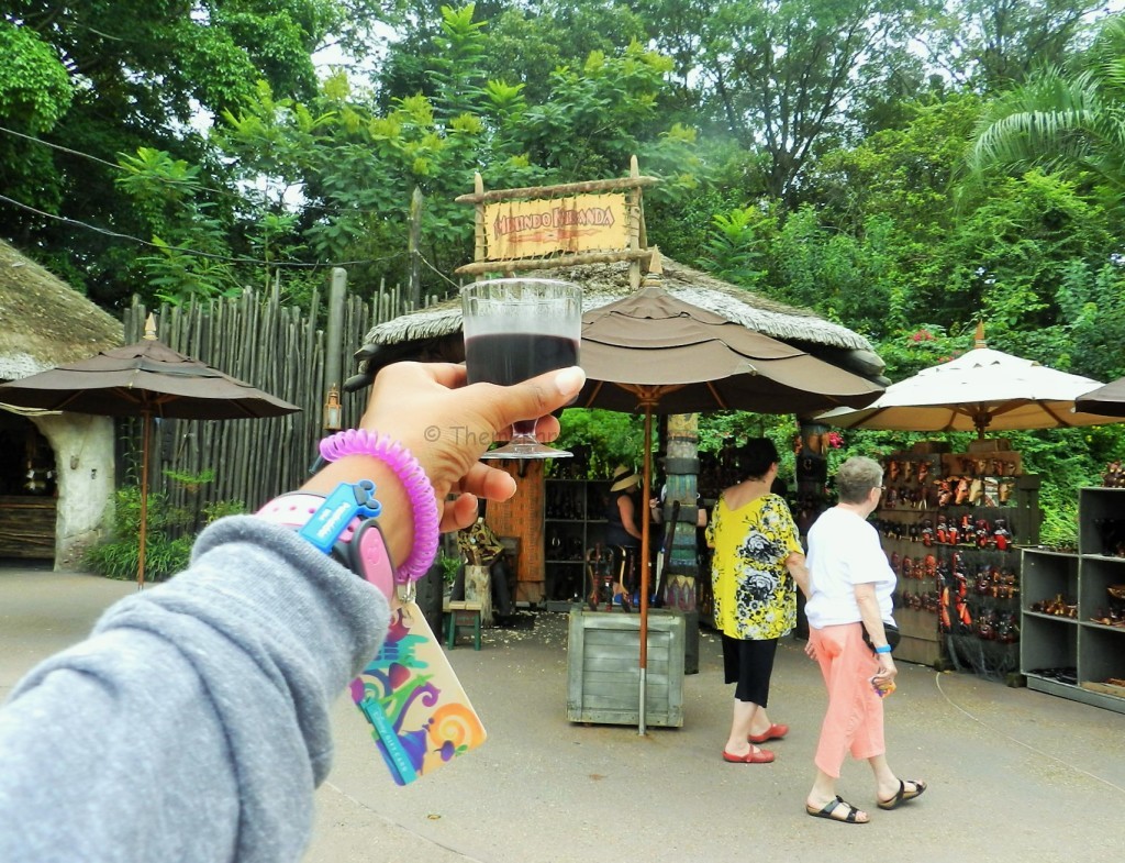 African Wine at Epcot Food and Wine Festival holding up wine with Disney gift card wristlet