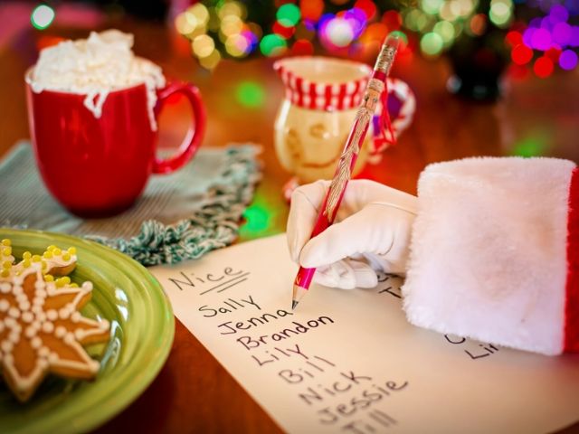 Busch Gardens Christmas Santa putting kids names on the list.