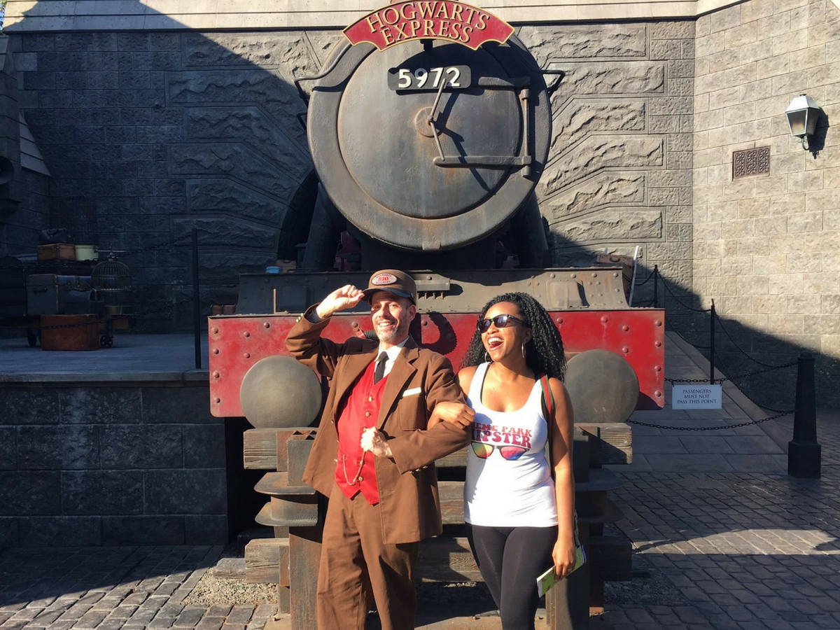 What to pack for universal orlando resort. Standing with Hogwarts Express Conductor in front of red train.
