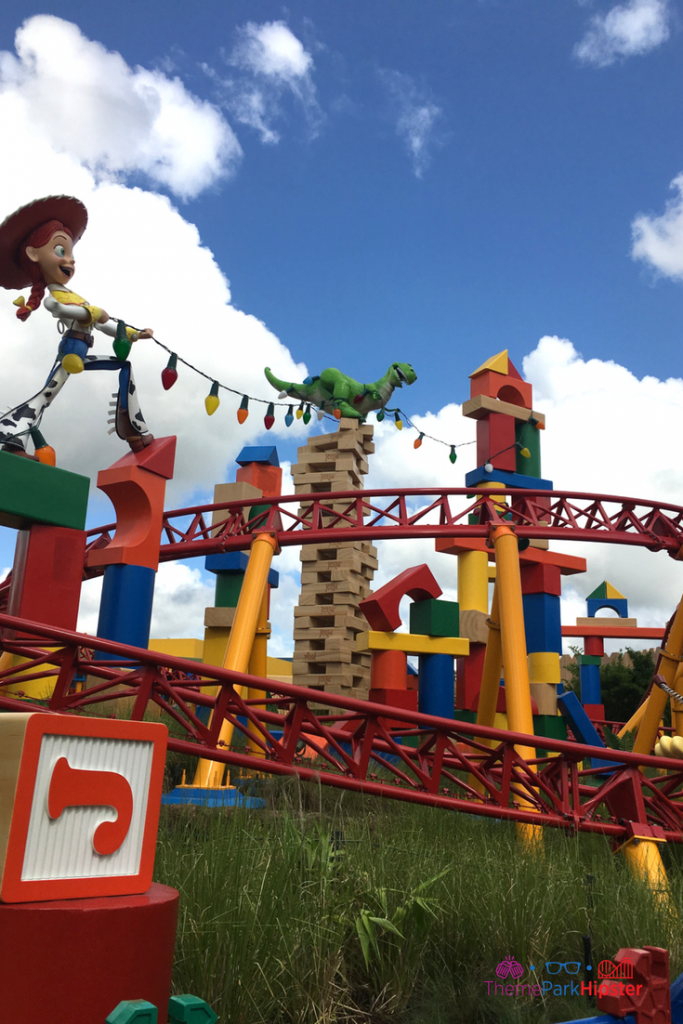Hollywood Studios Jessie holding Christmas lights in Toy Story Land. Keep reading to get the best Disney Christmas pictures and to know where to take the best Christmas photos at Disney World!