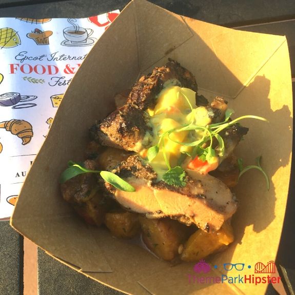 Jerk Chicken covered with mango salsa at Epcot Food and Wine Festival. Keep reading to learn about what's new and if the Epcot Food and Wine Festival is worth it?