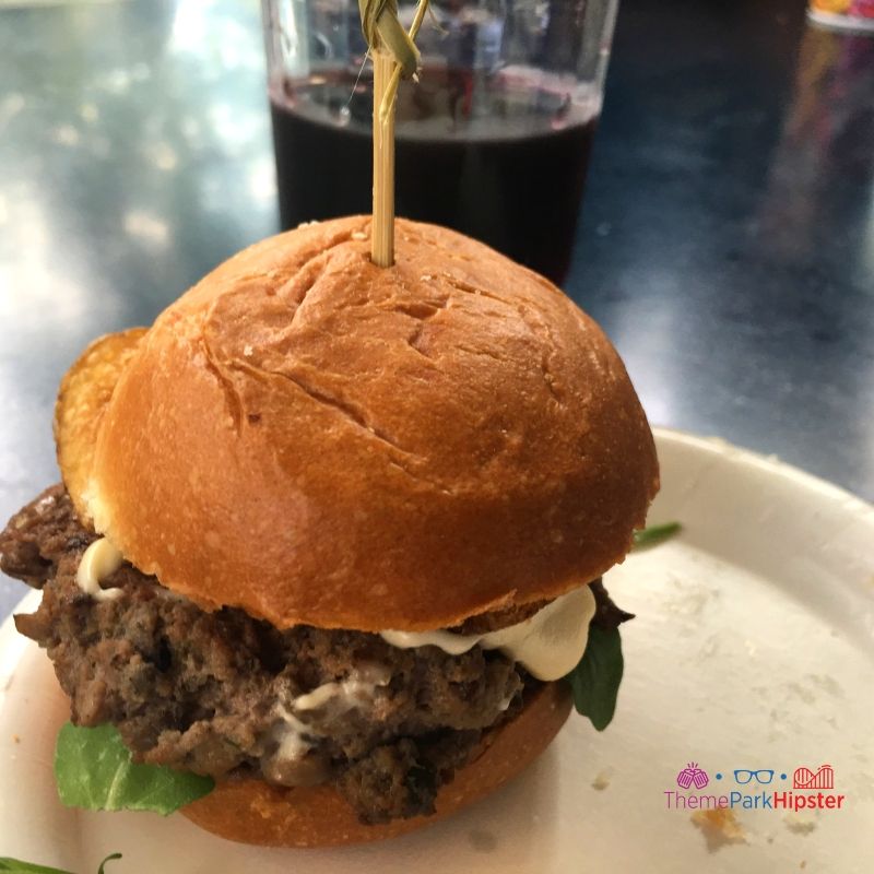 Steakhouse Blended Burger with blended beef and Mushroom Slider with brie cheese fondue, arugula, and a truffle and blue cheese potato chip on a brioche bun at Flavors from Fire Epcot. Keep reading to learn about the best food at Epcot Food and Wine Festival!