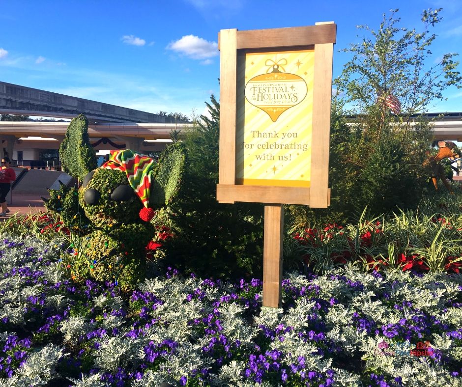 Epcot Festival of the Holidays entrance with topiary stitch for the Epcot Candlelight Processional.
