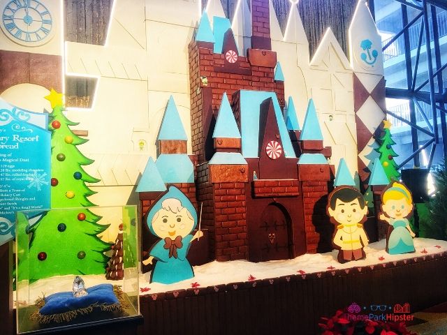 Cinderella Gingerbread House with a Small World Background at Disney Contemporary Resort. Keep reading to get your perfect Disney Resort Christmas Decorations Tour!