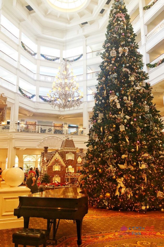 Casa de pan de jengibre del Grand Floridian con el majestuoso árbol de Navidad y el piano en el vestíbulo