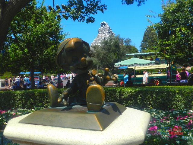 Disneyland Pinocchio Statue with Matterhorn in the Background. Keep reading to get the best days to go to Disneyland and Disney California Adventure and how to use the Disneyland Crowd Calendar.