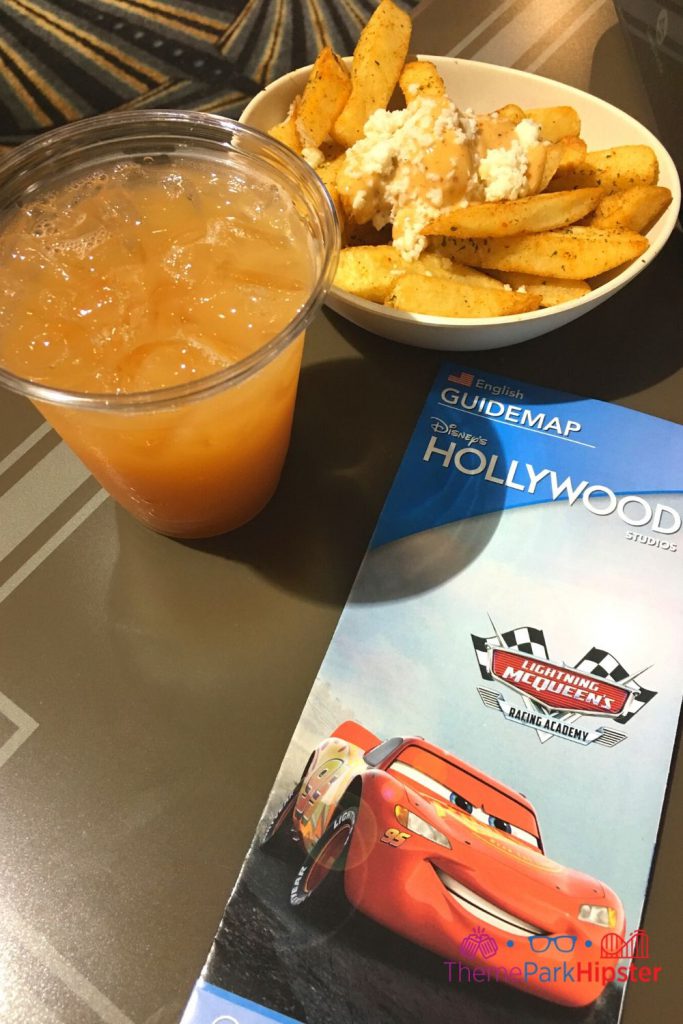 ABC Commissary Hollywood Fries with gravy and cheese and Happy Daze orange adult cocktail. One of the best counter service restaurants at Hollywood Studios.