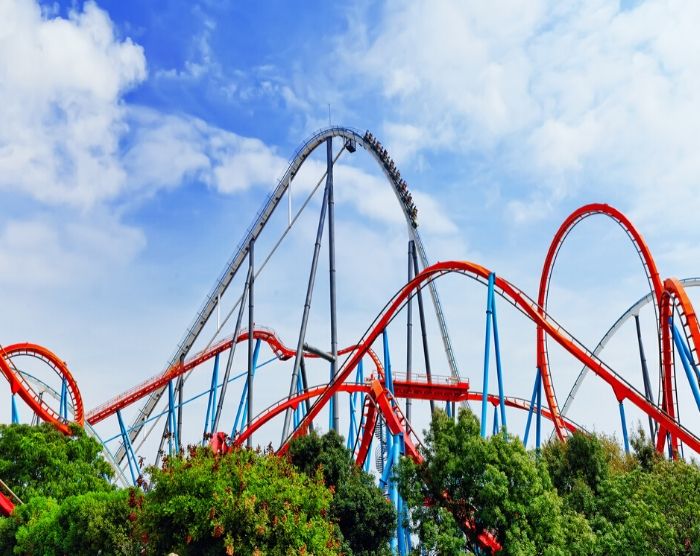 Solo Travel Tips for Theme Parks with Red and Blue Roller Coaster. Keep reading for the full female guide to solo travel.