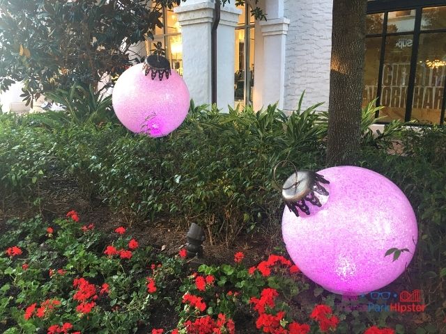 Disney Springs Christmas Decor with Pink Holiday Bulbs. Keep reading to get the full guide on Christmas at Disney Springs!