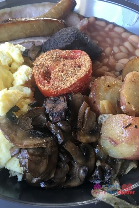 Traditional English Breakfast in Wizarding World of Harry Potter with eggs, sausage, black pudding, English bacon, baked beans, grilled tomato, sautéed mushrooms, and breakfast potatoes. A delicious Wizarding World of Harry Potter food.