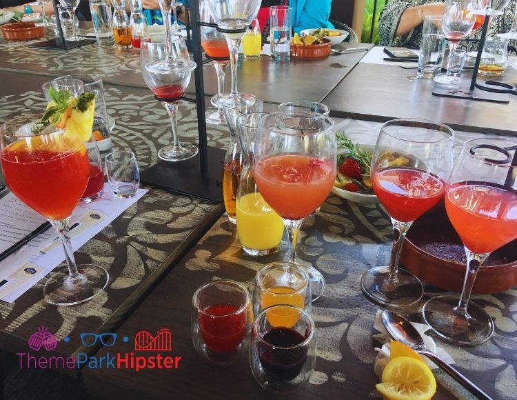 Various cups of colorful liquids and ingredients to create recipes at Disney Sangria University. Keep reading to find out more of the best things to do at Disney World on a solo trip.