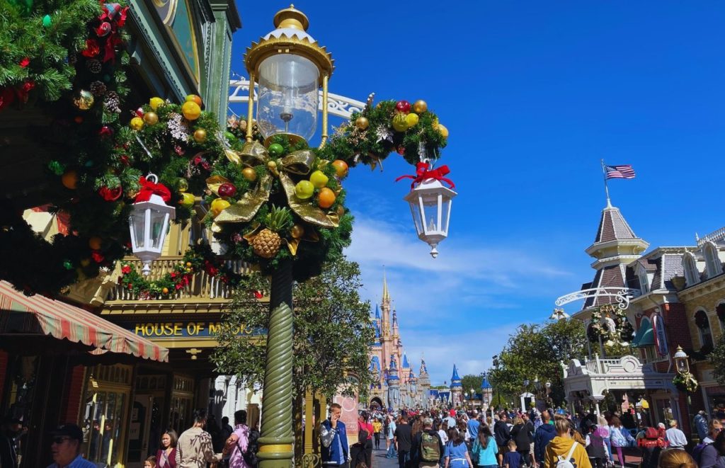 Disney Christmas decorations in Magic Kingdom with Cinderella Castle in the Background. Keep reading to get the best Disney Christmas songs!