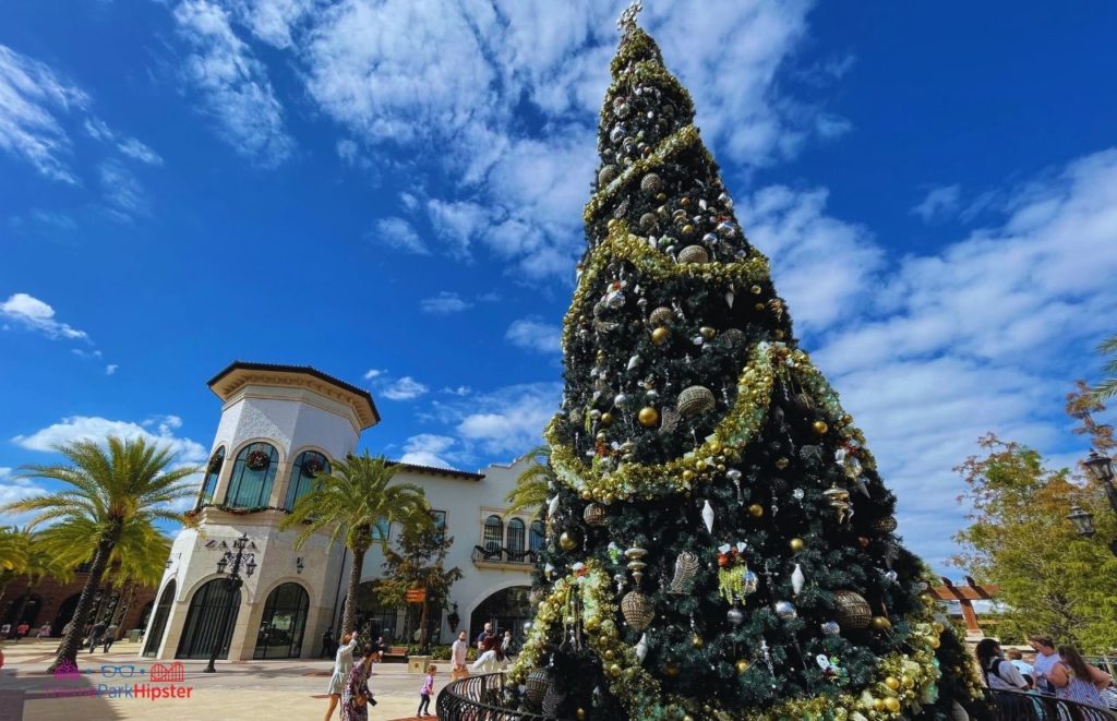 Disney Springs Main Christmas Tree with Zara Store in Background. Keep reading to get the full guide on Christmas at Disney Springs!