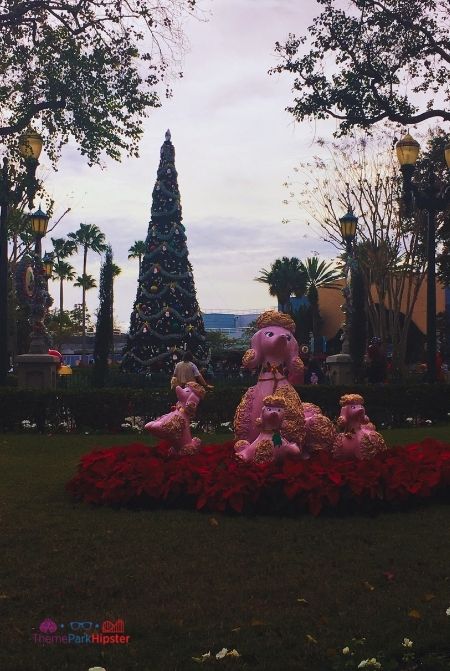 Hollywood Studios Christmas tree and decorations with pink poodle dog like large ornaments. Keep reading to learn about the best things to do at Disney World for Christmas.