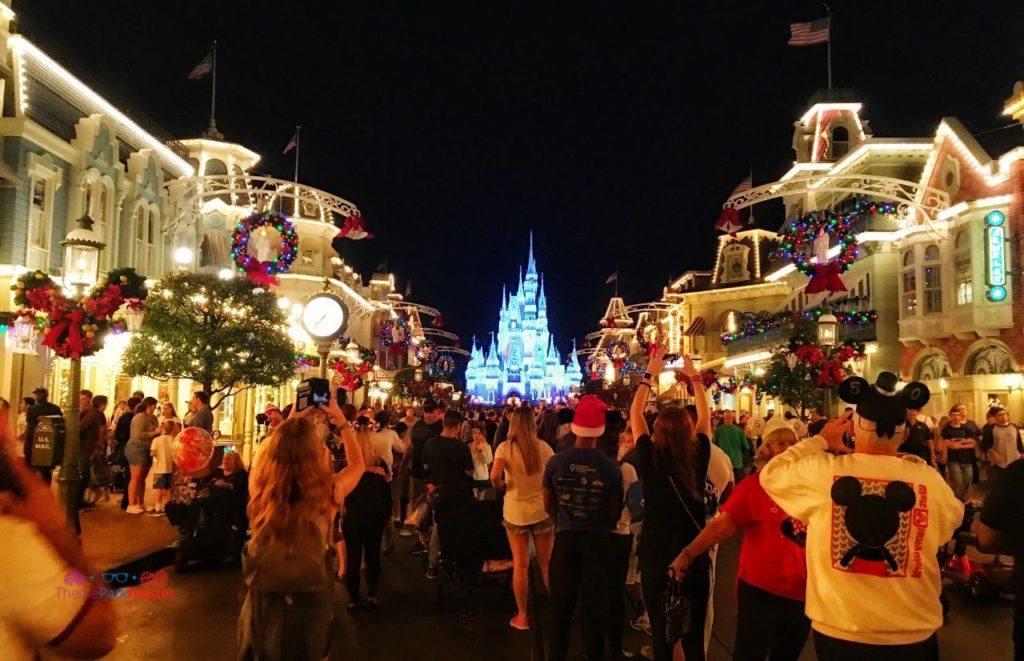 Shimmering Cinderella Castle with Christmas Lights at the Magic Kingdom. Keep reading to get the best things to do at the Magic Kingdom for Christmas and a full guide to Mickey's Very Merry Christmas Party Tips!