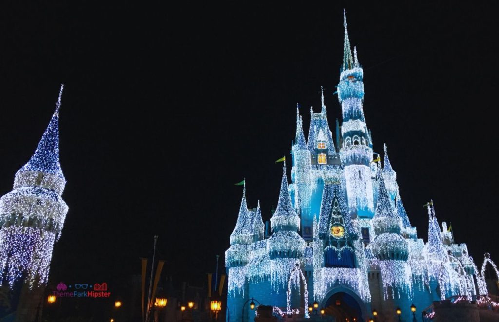Shimmering Cinderella Castle with Christmas Lights at the Magic Kingdom Florida. Keep reading to get the best Disney Christmas quotes for the holidays!