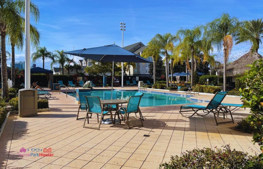 Hilton Garden Inn International Drive Pool with outdoor seating, sun loungers and umbrellas. Keep reading if you want to learn more about HHN hotels.