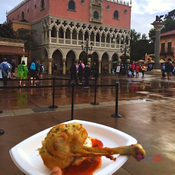 Chicken on top of tomato sauce in Italy Pavilion at Epcot Festival of the Arts. Keep reading to get the full Epcot Festival of the Arts Menu!