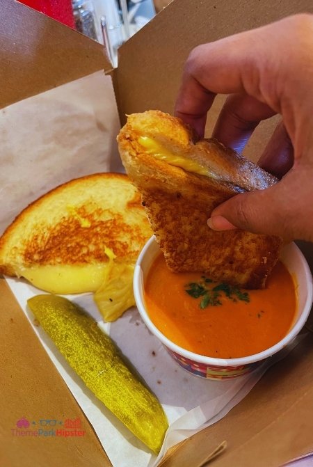 Disney Beach Club Resort Hotel Grilled Cheese Sandwich with Tomato Soup and Pickle in To Go Box at Disney's Beaches and Cream Soda Shop.