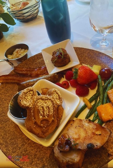 Napa Rose Disney Princess Adventures Breakfast at Disneyland with Mickey Mouse Waffles Bacon Sausage Green beans Mac and Cheese and Strawberry. Keep reading to get the best restaurants at Disneyland for adults.