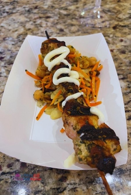 Epcot International Festival of the Arts 2023 Tangerine Cafe Morocco Chicken Skewer. Keep reading to get the full Epcot Festival of the Arts Menu!