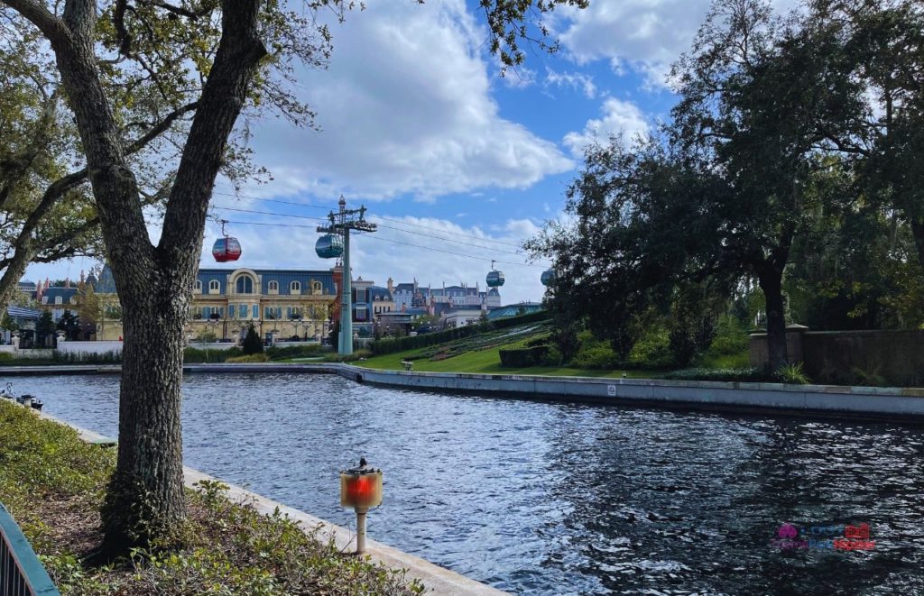 Epcot Skyliner over canal at Walt Disney World. Keep reading to get the full Disney World Skyliner Guide with the Cost, Hours, Tips and more!