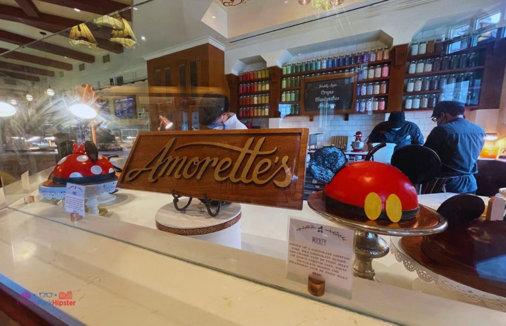 Dessert Minnie and Mickey Mouse Cake at Disney Springs Amorette’s Pâtisserie with cake making in the background. Keep reading to discover the most romantic things to do at Disney World for couples. 