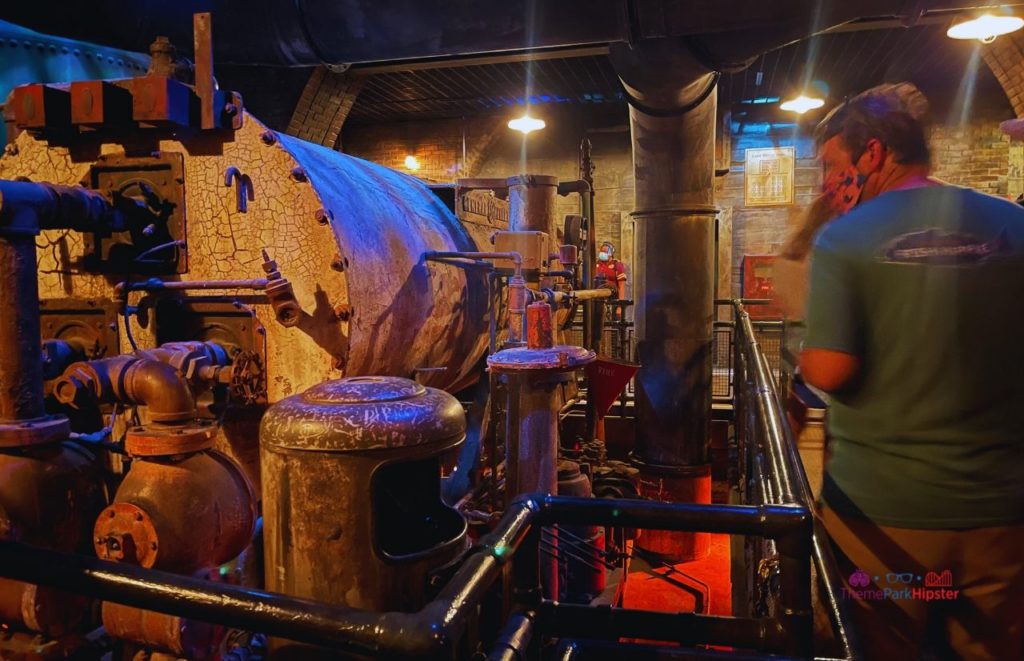 Interior of Disney World Hollywood Studio's Twilight Zone Tower of Terror, showcasing large aging industrial tanks, oil barrels, engines, and pipes.  If you want to take deep dive into Twilight Zone Tower of Terror: Secrets REVEALED, keep reading!
