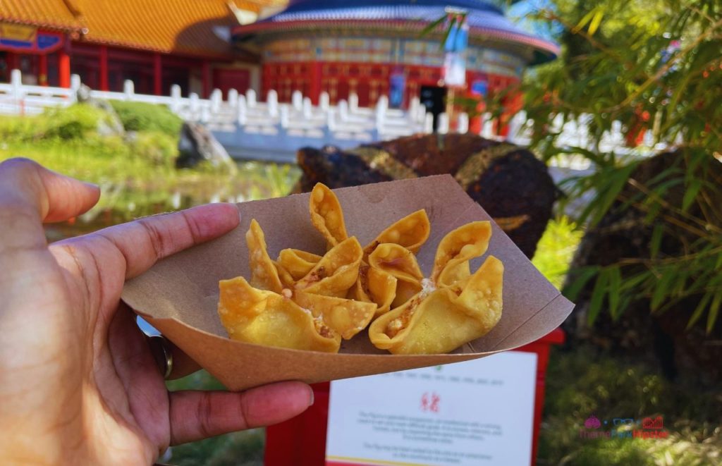 Epcot China Pavilion Flower and Garden Festival Cheese Wontons overlooking temple. Keep reading for the best Epcot International Flower and Garden Festival tips!