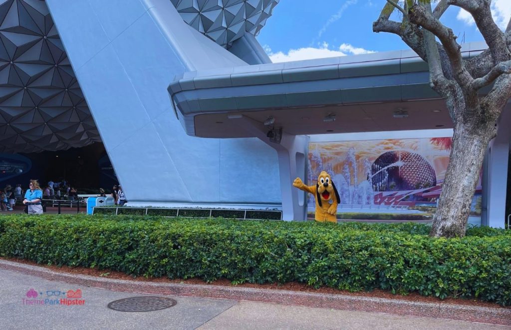Pluto in fronts of Spaceship Earth mural at Epcot 