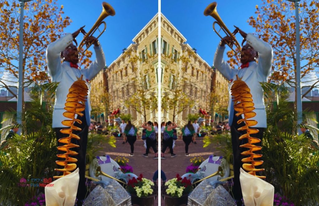 2024 Twisted Taters in front of Black man on trumpet at Universal Studios Mardi Gras