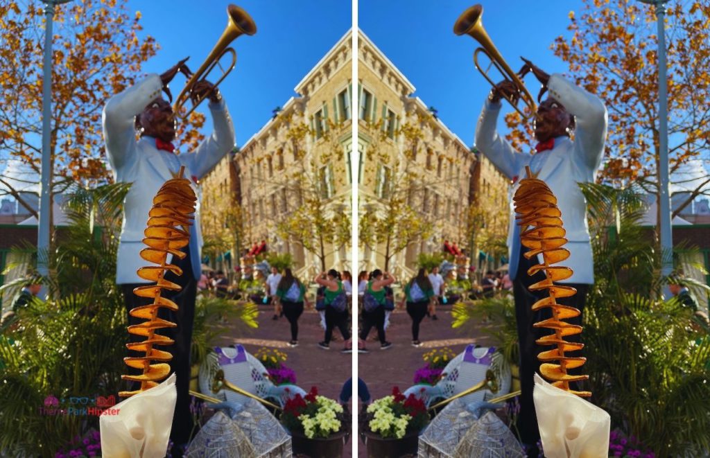 Twisted Taters in front of Black man on trumpet at Universal Studios Mardi Gras. Keep reading to get the best things to do at Universal Orlando solo trip while going to Universal alone.