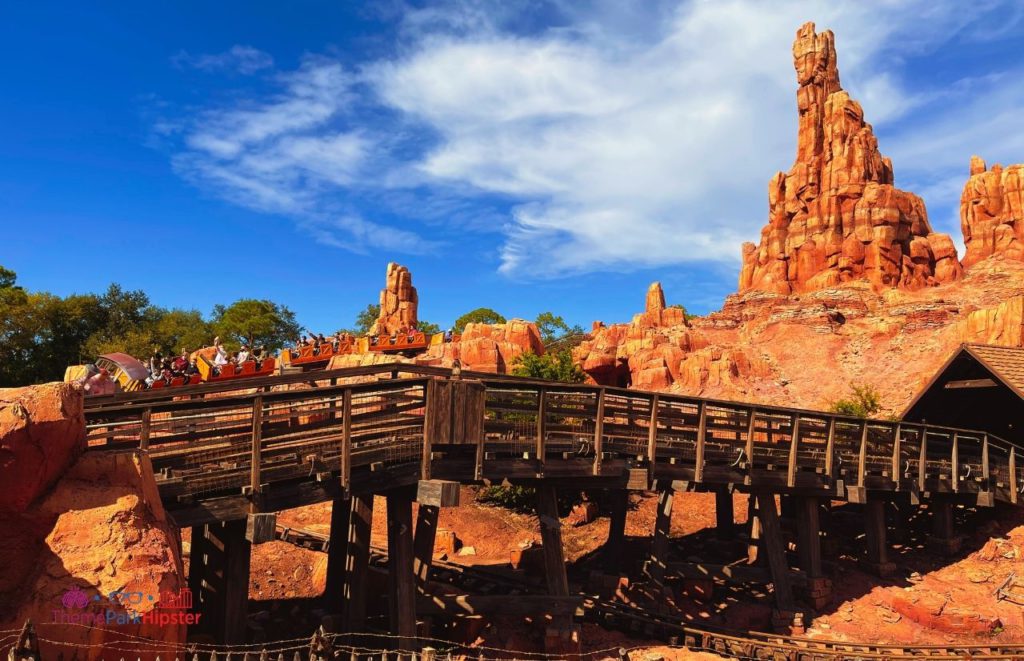 Disney Magic Kingdom Big Thunder Mountain Railroad roller coaster going over the bridge Frontierland. Keep reading for you perfect Disney World itinerary.