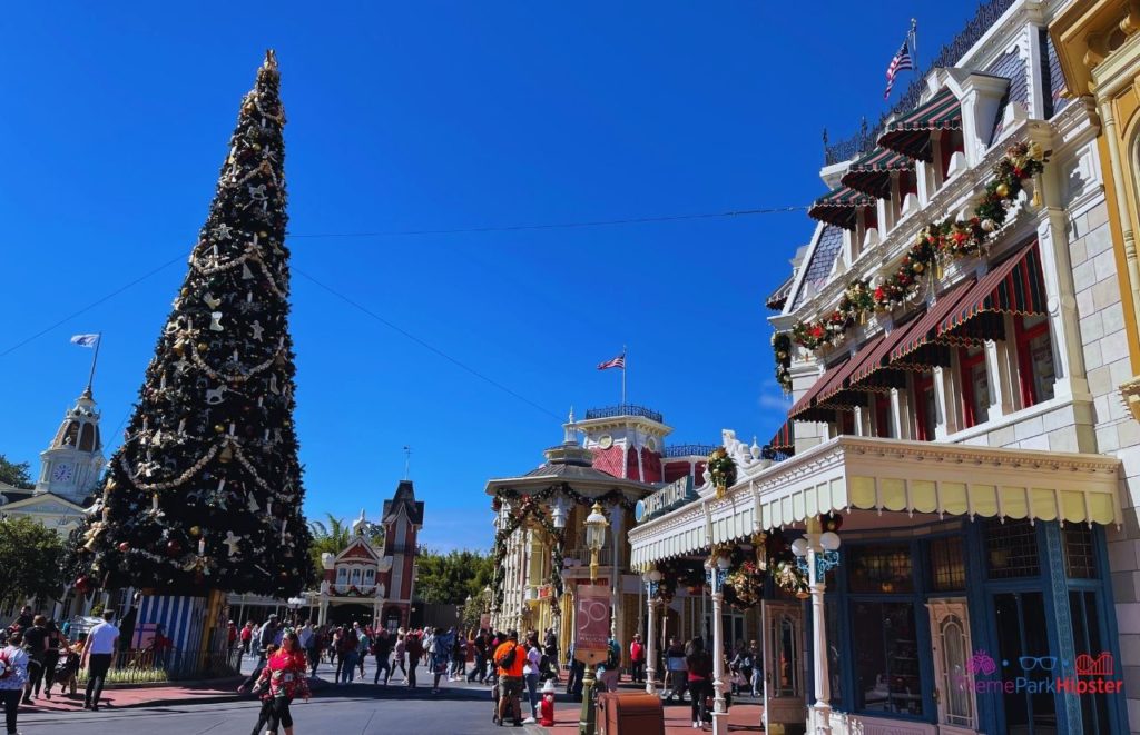 Disney Magic Kingdom Main Street USA with Christmas Tree. Keep reading to get the best things to do at the Magic Kingdom for Christmas and a full guide to Mickey's Very Merry Christmas Party Tips!
