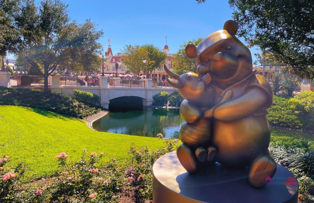 Disney Magic Kingdom Winnie the Pooh and Piglet Statue overlooking water. Keep reading to learn more about which Orlando theme park is the best. 