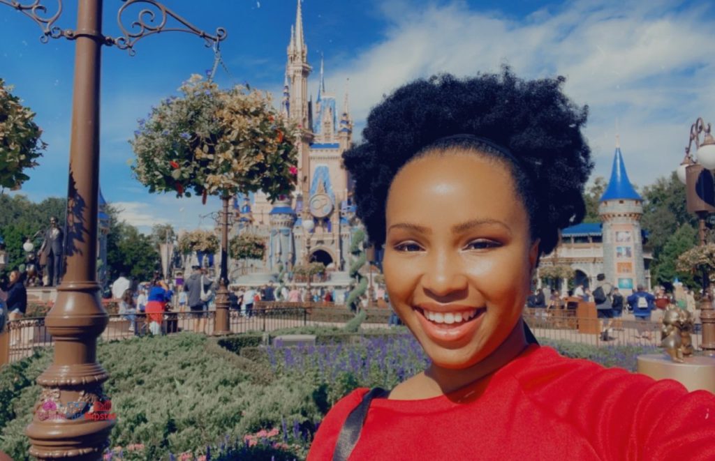 NikkyJ in front of Cinderella Castle at the Magic Kingdom. Keep reading to learn about the best Disney park for adults.