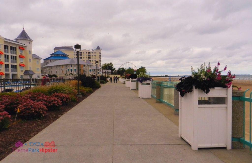 Cedar Point Hotel Breakers Boardwalk next to Lake Erie with colorful flowers on either side of the boardwalk. Keep reading to find out more about the best things to do at Cedar Point. 