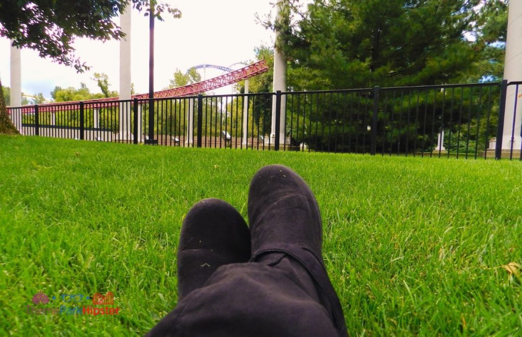 Cedar Point NikkyJ on grassy lawn next to Top Thrill Dragster. Keep reading for more Cedar Point tips and tricks for beginners.