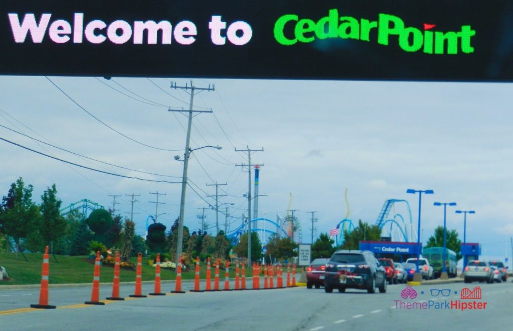 Cedar Point welcome sign at entrance with line for parking. Keep reading to learn about Valravn roller coaster at cedar point.