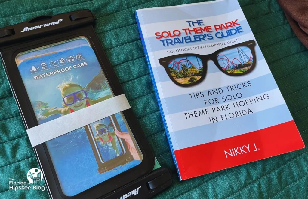 Waterproof Phone Case next to The Solo Theme Park Traveler's Guide by NikkyJ. Keep reading to get the best water park tips.