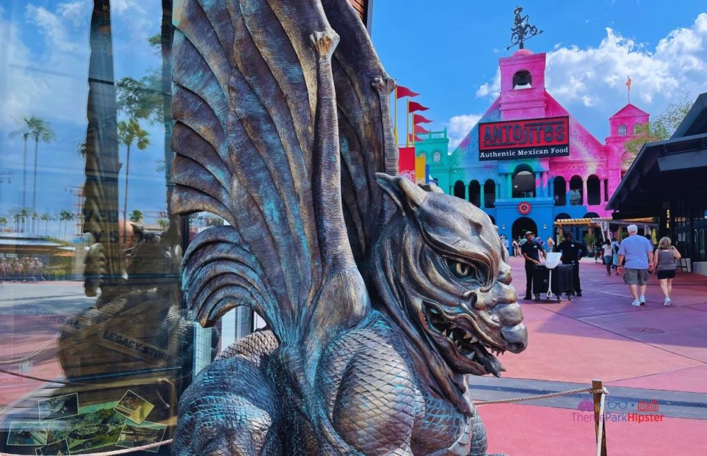Universal Orlando Resort Antojitos in background for gargoyle statue at Legacy Store in City. Keep reading to learn about the best Universal Orlando Resort restaurants for solo travelers.