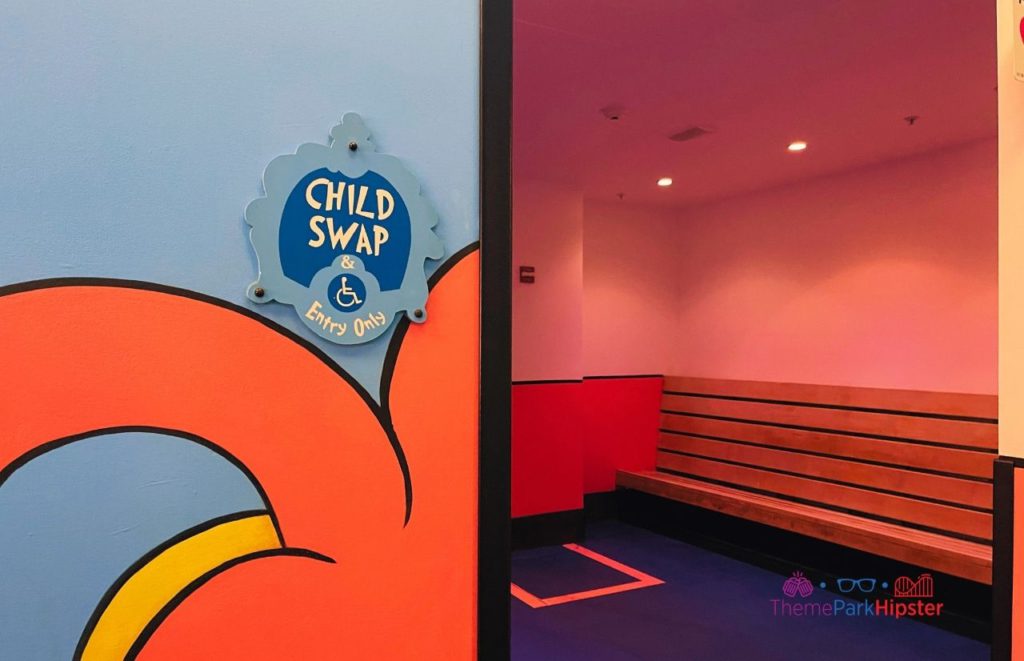 Blue Child Swap sign hanging on a colorful cartooned wall at Seuss Landing at Universal's Island of Adventure. Keep reading to to find out more Mistakes to Avoid at Universal Orlando Resort!