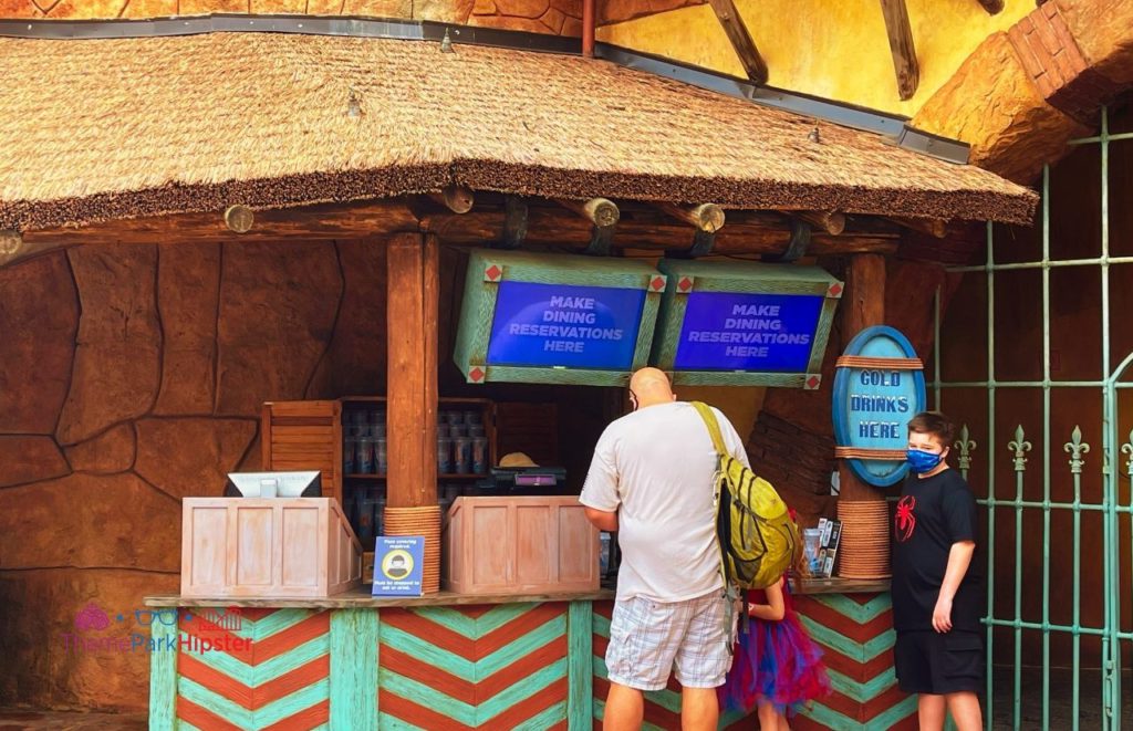Two guests in line at the Tiki-clad Universal Orlando Resort Dining Reservation Kiosk in Islands of Adventure. Keep reading to to find out more Mistakes to Avoid at Universal Orlando Resort!