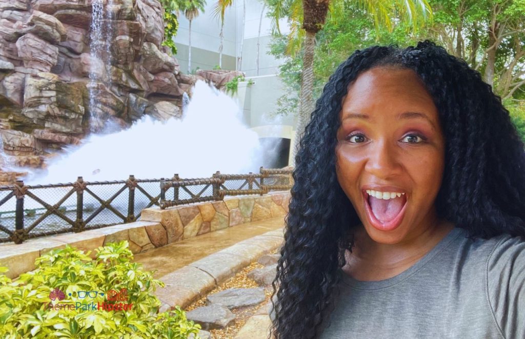 Universal Orlando Resort NikkyJ behind Thunder Falls Terrace in Jurassic Park in Islands of Adventure with River Adventure Boat splashing Down. Keep reading to learn how to have the best Universal Orlando Solo Trip for Travelers going to theme parks alone.