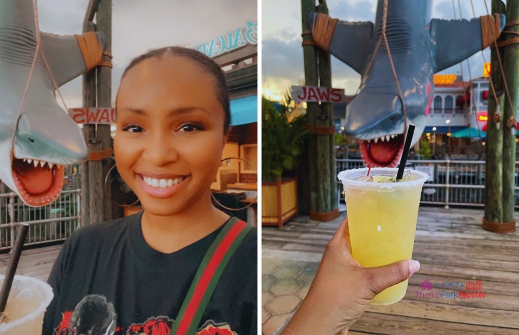 NikkyJ enjoying a margarita at Chez Alcatraz at Universal Orlando Resort with Jaws Bruce the Shark in background at Universal Studios. Keep reading to discover what are the best bars at Universal Orlando.  